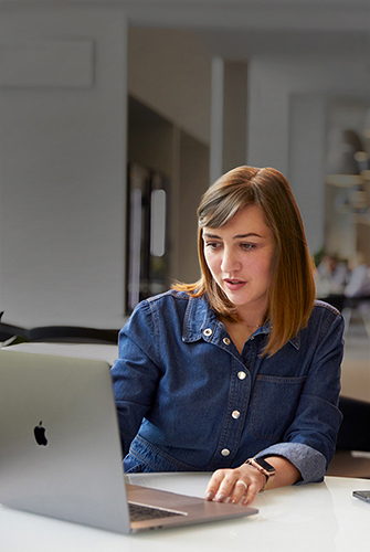 Una persona del team Supporto e assistenza di Apple che lavora su un MacBook in un’area comune.