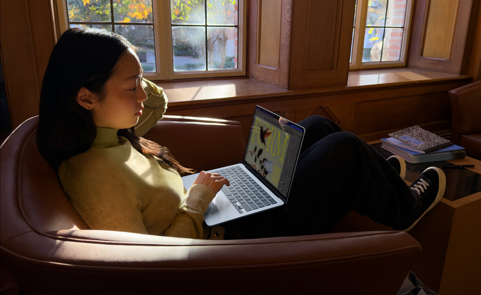 A person sitting in a chair using their MacBook Air