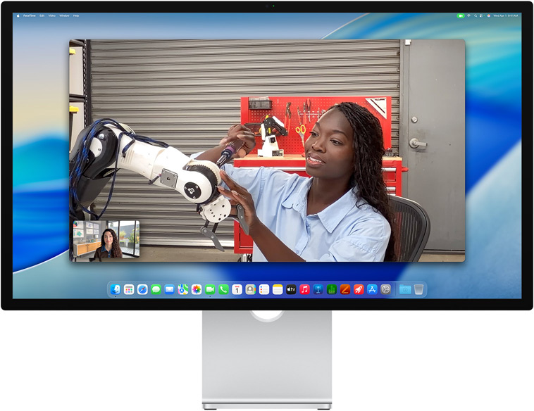 Duas pessoas numa videochamada no Studio Display, o Enquadramento central mantém-nas no centro da imagem, mesmo enquanto uma pessoa se movimenta para reparar um equipamento