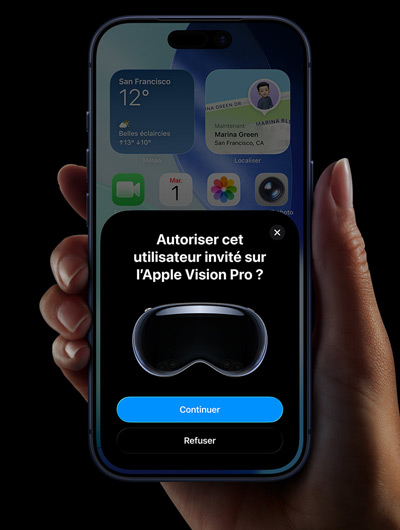 Une main tenant un iPhone. L’écran affiche une fenêtre avec le message « Autoriser cet utilisateur invité sur l’Apple Vision Pro » et les boutons « Continuer » et « Refuser »
