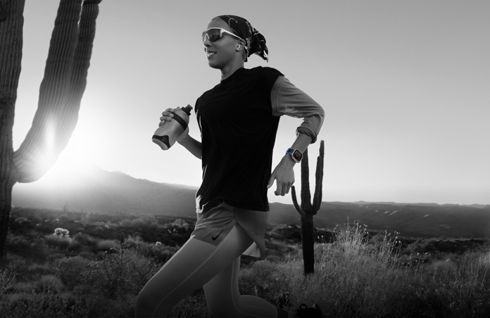 A person uses Apple Watch Ultra 3 while running on a desert trail