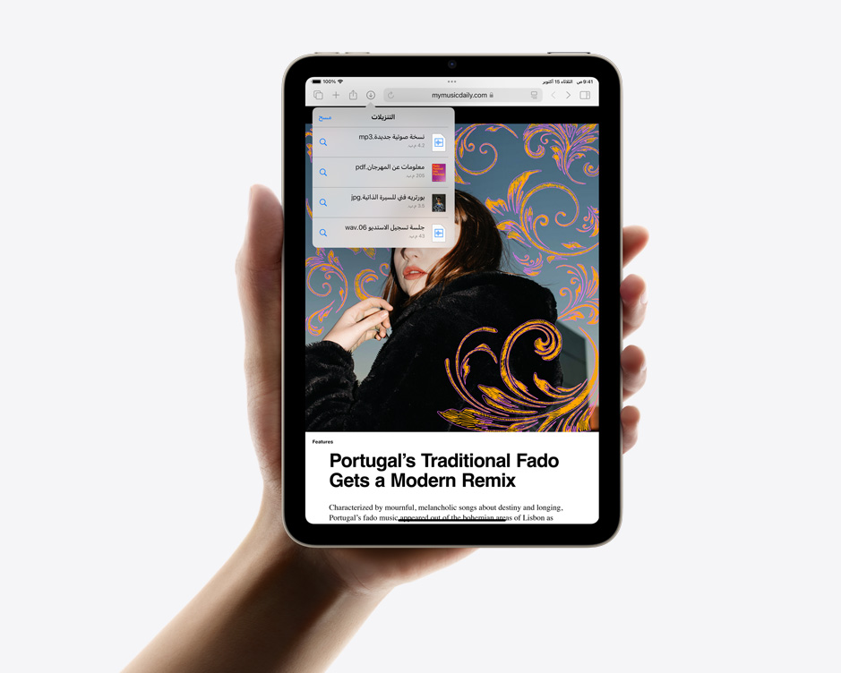 iPad mini محمول بيد واحدة في وضع رأسي ويعرض عمليات التنزيل في سفاري.
