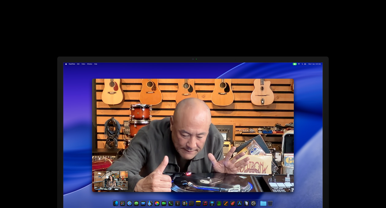 While on a video call, a person at a music store looks closely at a turntable, he remains centered in the frame thanks to the Center Stage camera