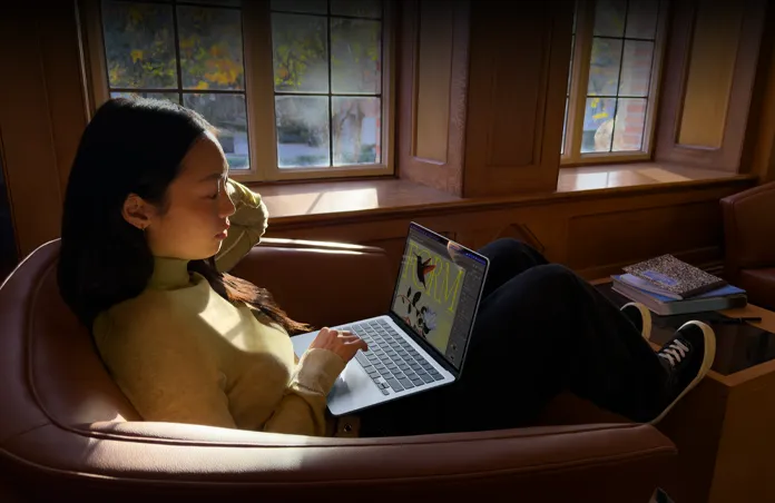 一個人坐在椅子上使用 MacBook Air