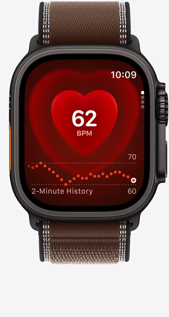 Apple Watch Ultra 4, screen shows Heart Rate app, current beats per minute, titanium case, black colour, connected to Trail Loop strap, dark umber colour (brown)