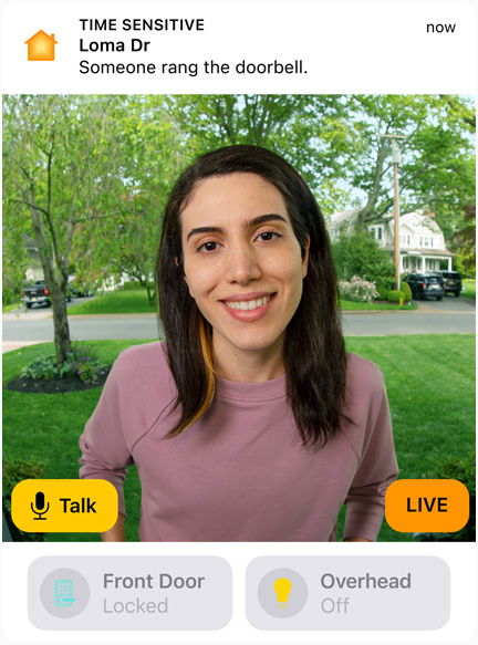 Die Ansicht einer Türklingel-Kamera mit einer Frau in einem rosa Sweatshirt. Das Display zeigt die Wörter „Sprechen“ und „Live“.
