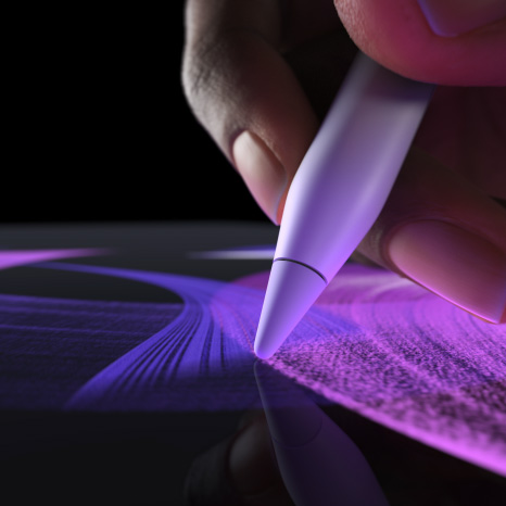 Imagem lateral do Apple Pencil Pro branco, com uma mão desenhando uma linha vibrante com pincel azul
