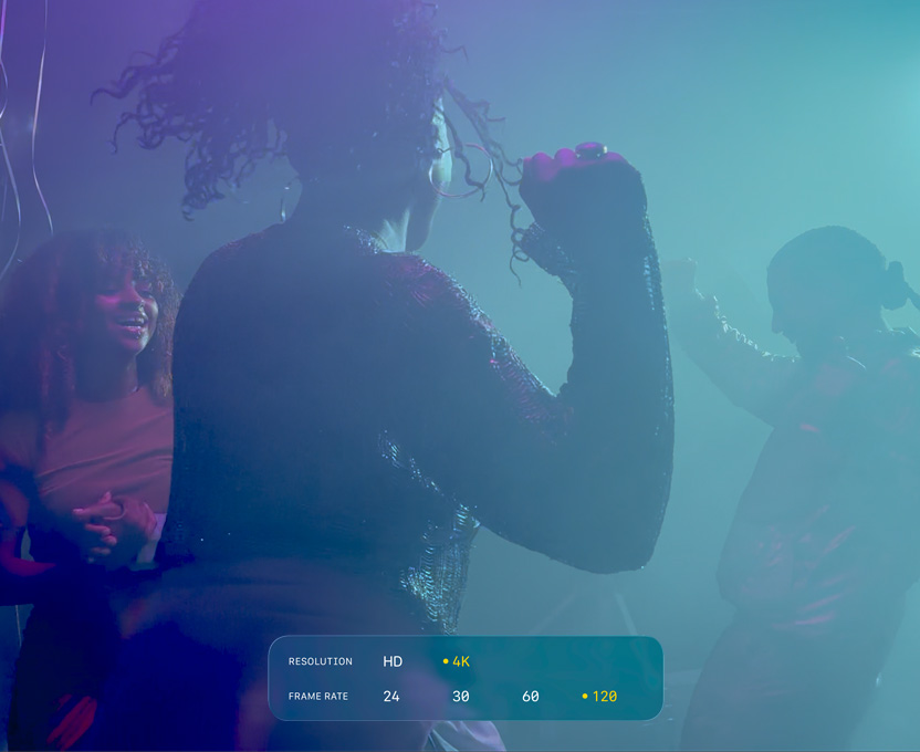 A screen of people dancing in low-light filming conditions shows the capabilities of 4K 120 fps Dolby Vision