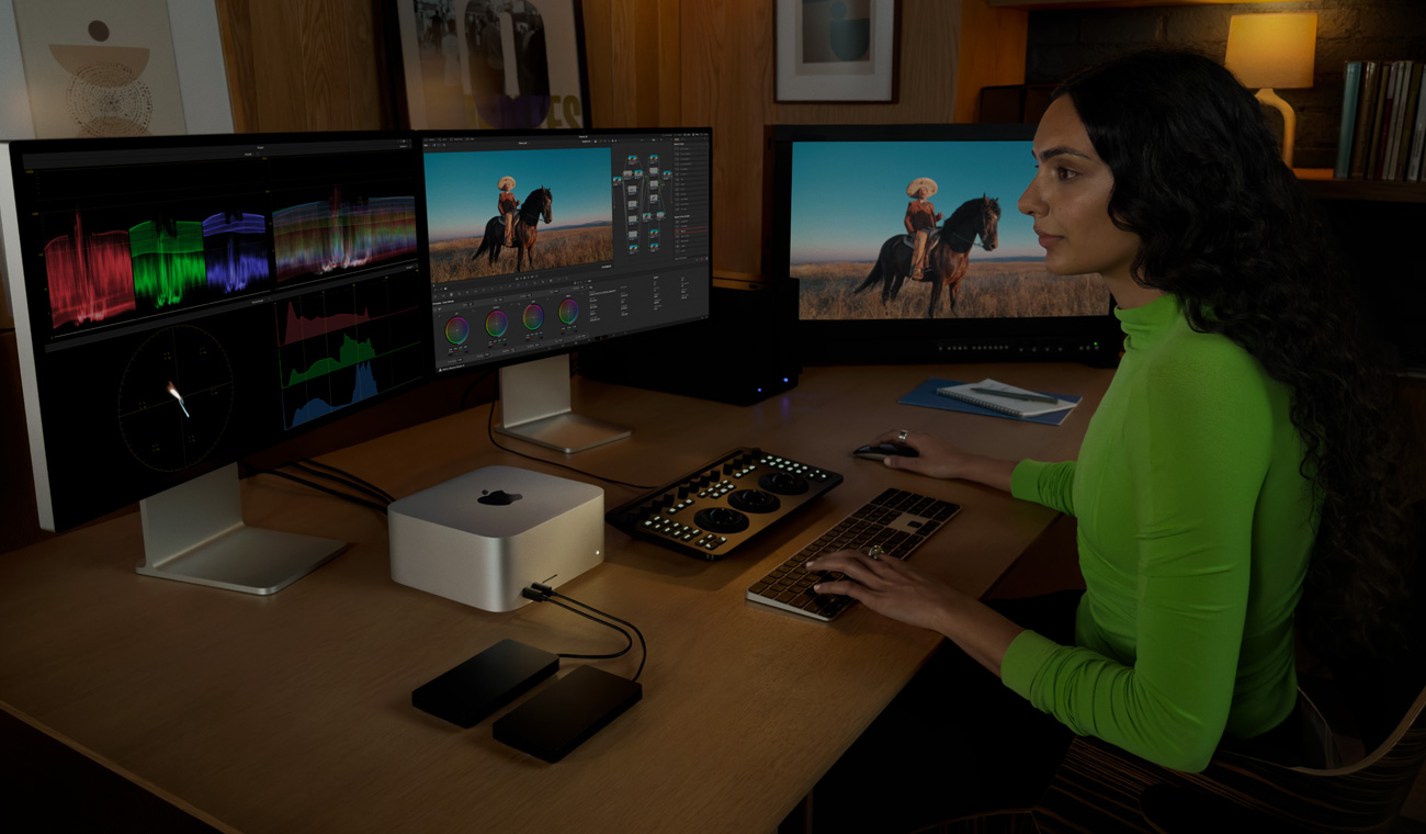Mac Studio’ya bağlanan bir profesyonel, üç ekranda dosyaları düzenliyor
