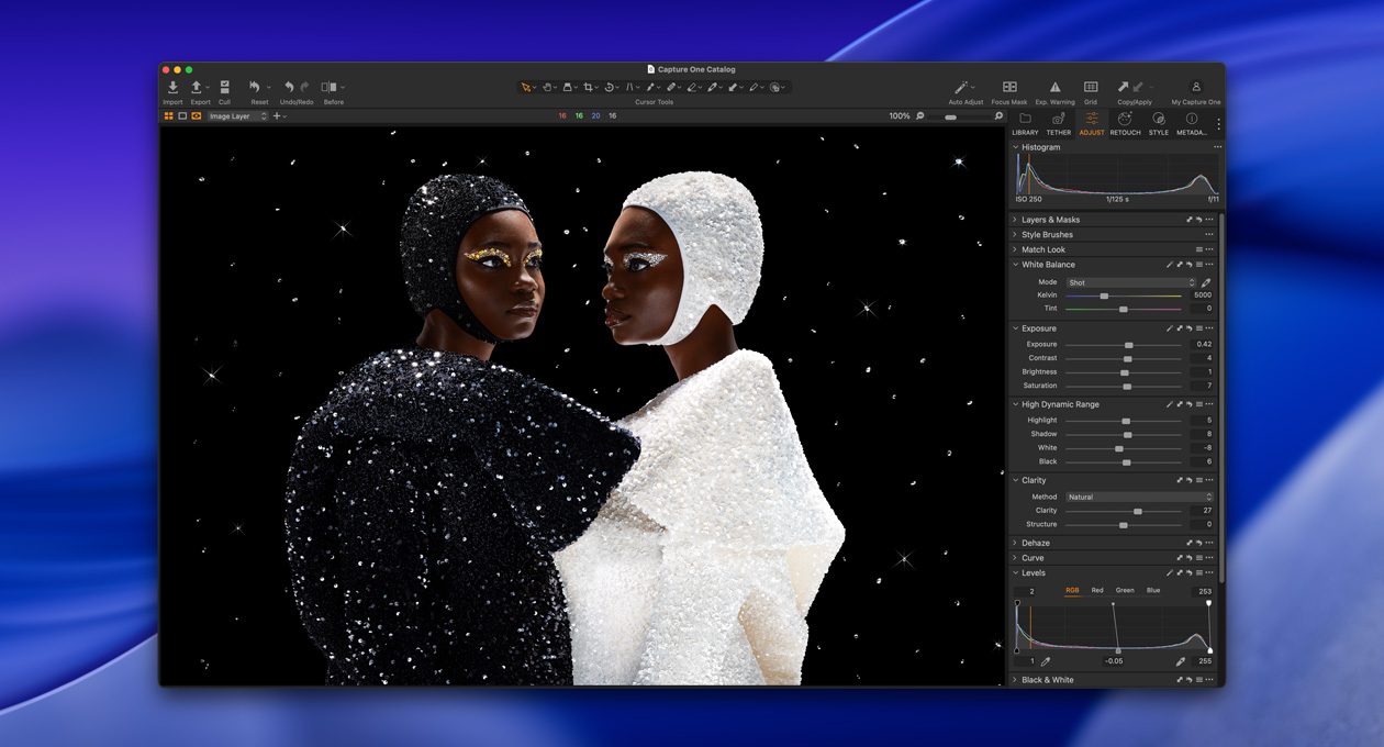 Une personne vêtue de noir se tient de profil à côté d’une personne vêtue de blanc, mettant en avant la luminosité et le contraste offerts par le Studio Display XDR